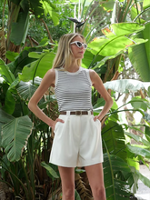 a lady wears a knitted tank top with white shorts
